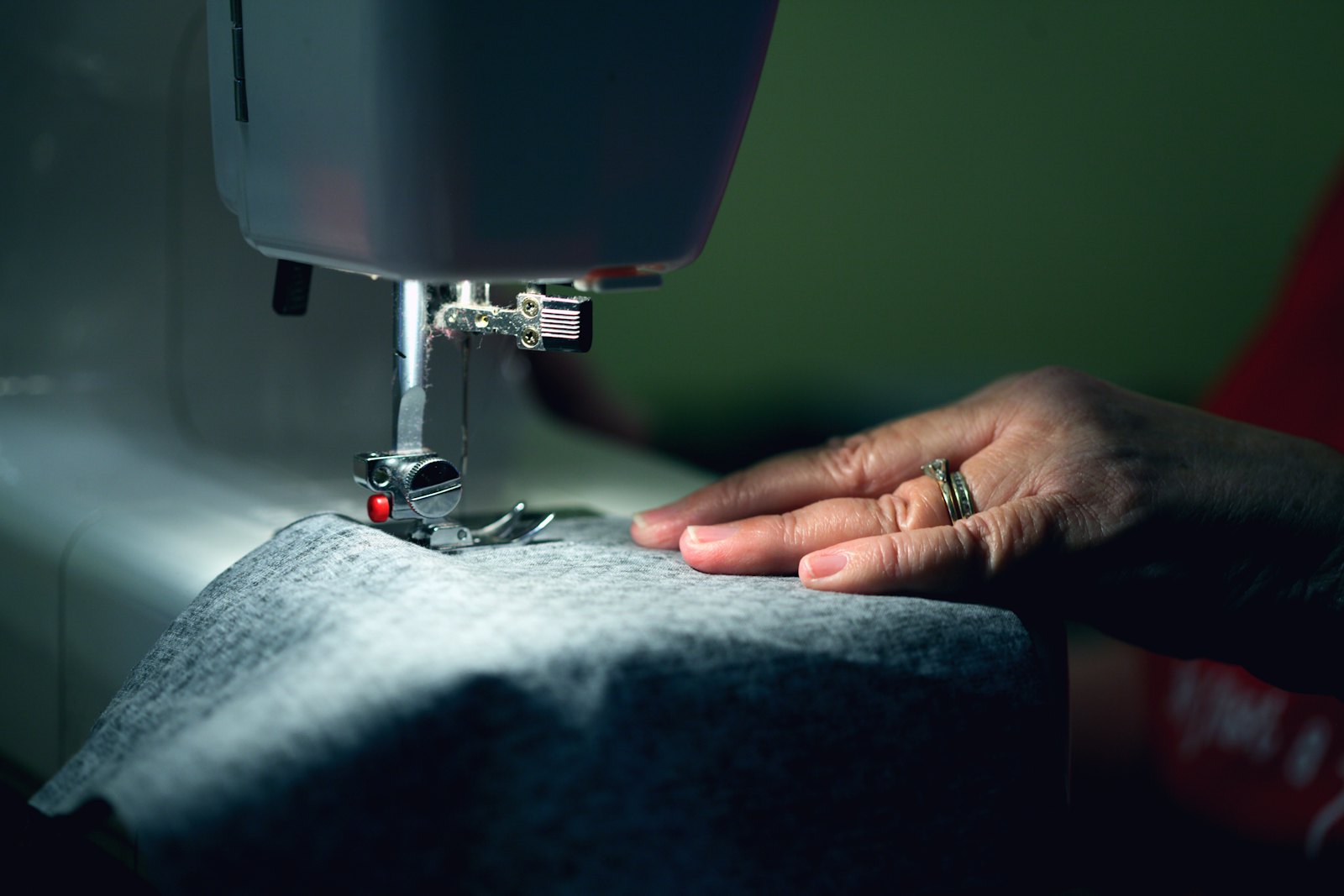 Manos cosiendo una prenda en una máquina de coser.
